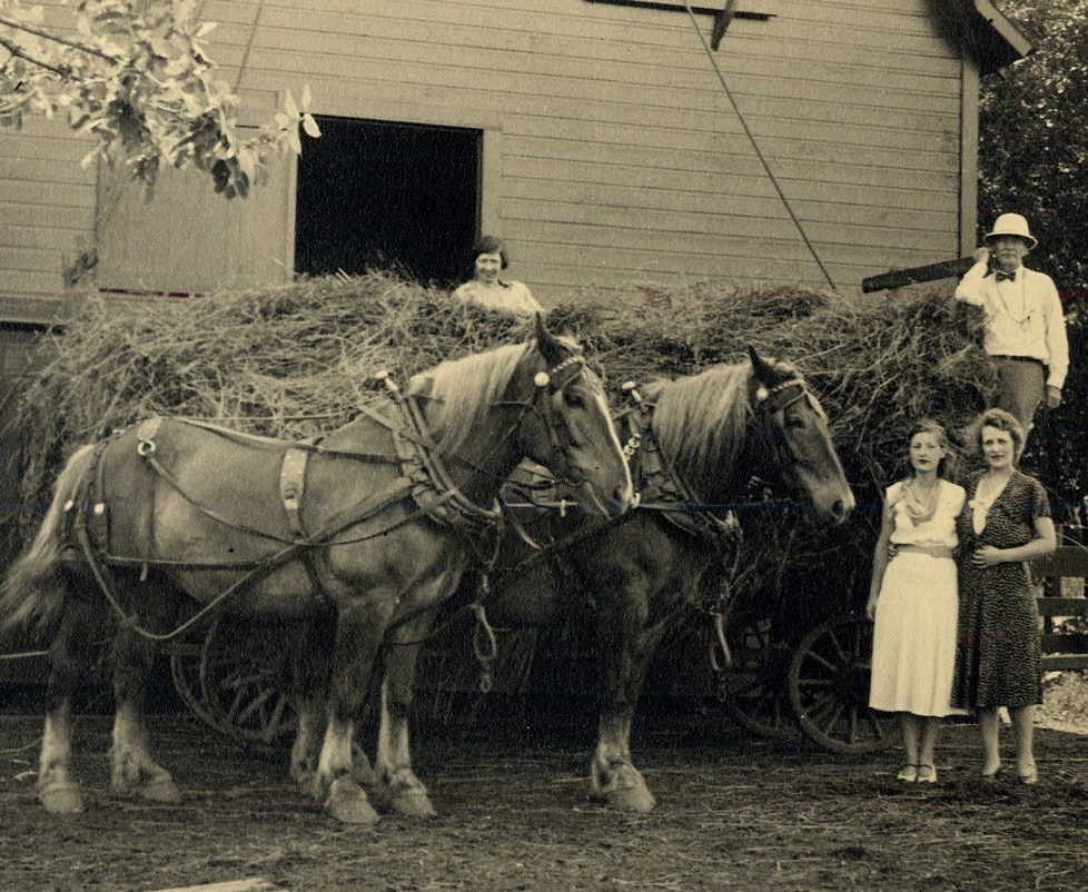 Mott family at stable with horses and hay