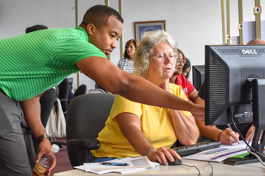 Man points to the computer screen in front of a woman.