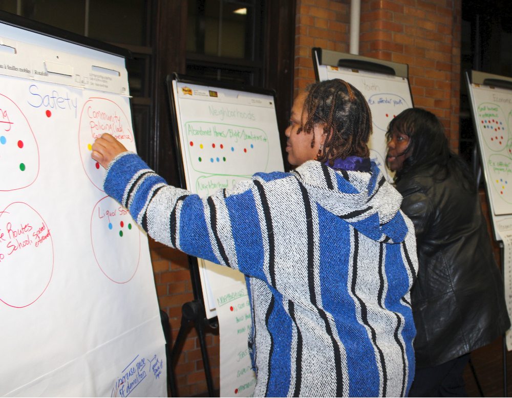 A north Flint resident participates in dot voting at a Ruth Mott Foundation community forum in 2015.
