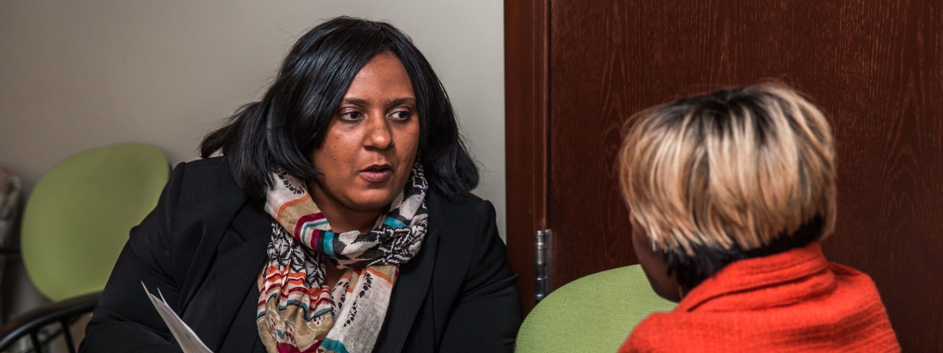 Tryphena Clarke, Community Engagement Specialist, talks to an attendee at a Ruth Mott Foundation information session