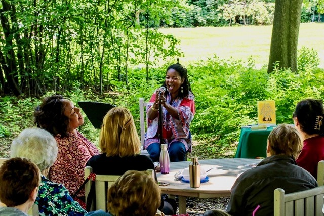 Woman speaks to a group gathered outside at Applewood