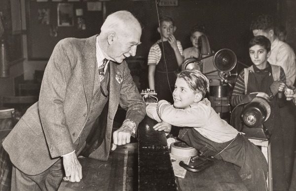 C.S. Mott poses with a child in a Flint school workshop