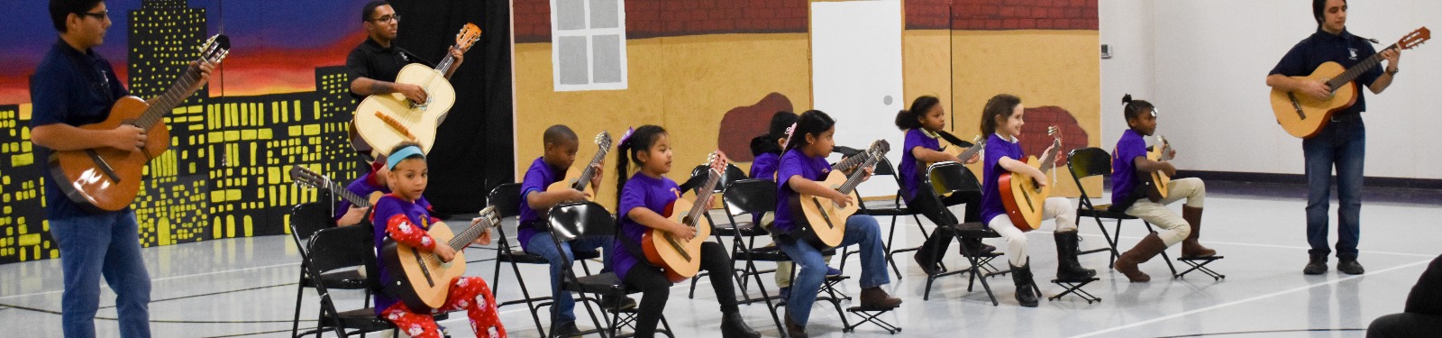 Students play guitar at a recital