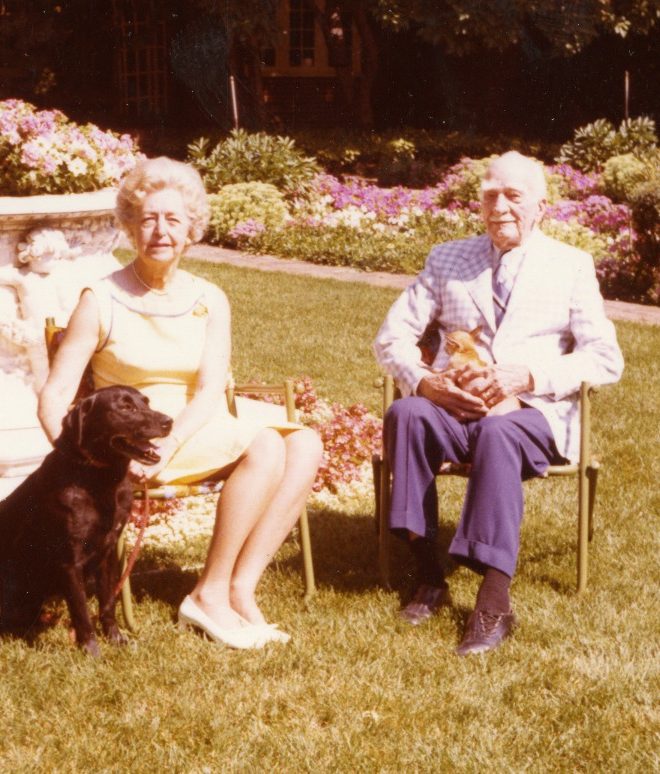 Ruth and CS Mott pose near the marble wellhead with dogs