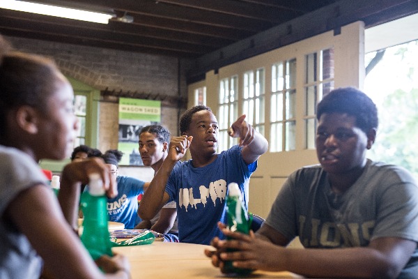 Field Trip Students talking while sitting at tables in the barn classroom at Applewood