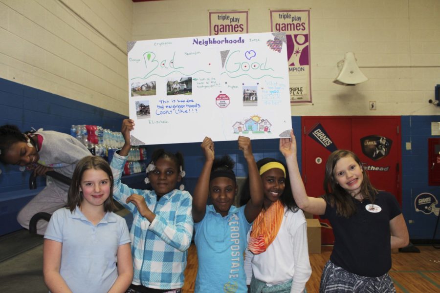 Youth hold up poster boards