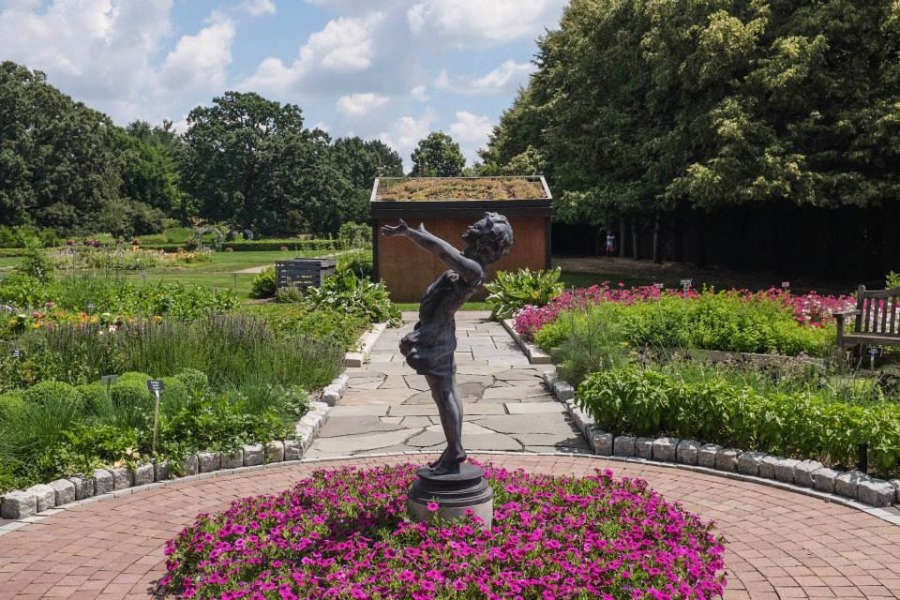 A side view of a statue of a girl with her arms outstretched is pictured at Applewood