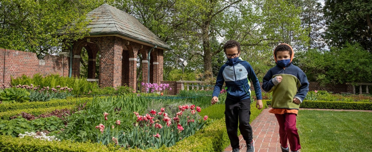 two children run through the perennial garden at Applewood