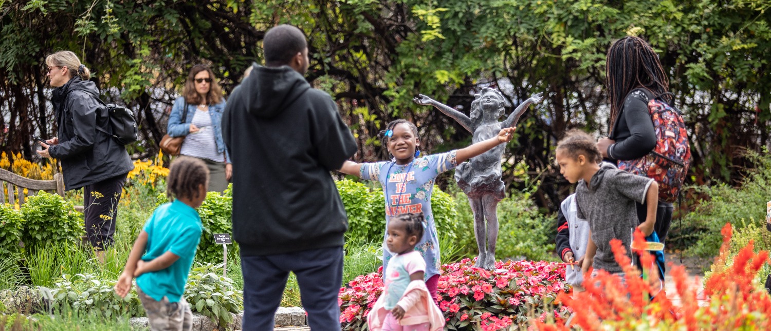 Children pose next to the la brezza sculpture in the garden at Applewood