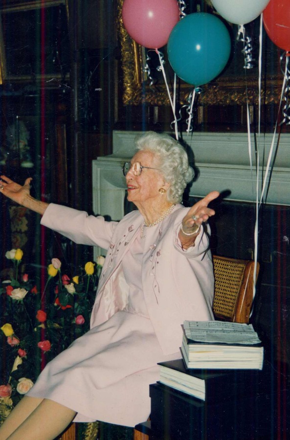 Ruth Mott pictured on her 90th birthday, arms outstretched to her guests