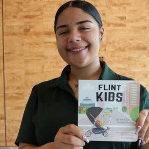 Olivia Holden, author of the Flint Kids Book, is pictured with the book