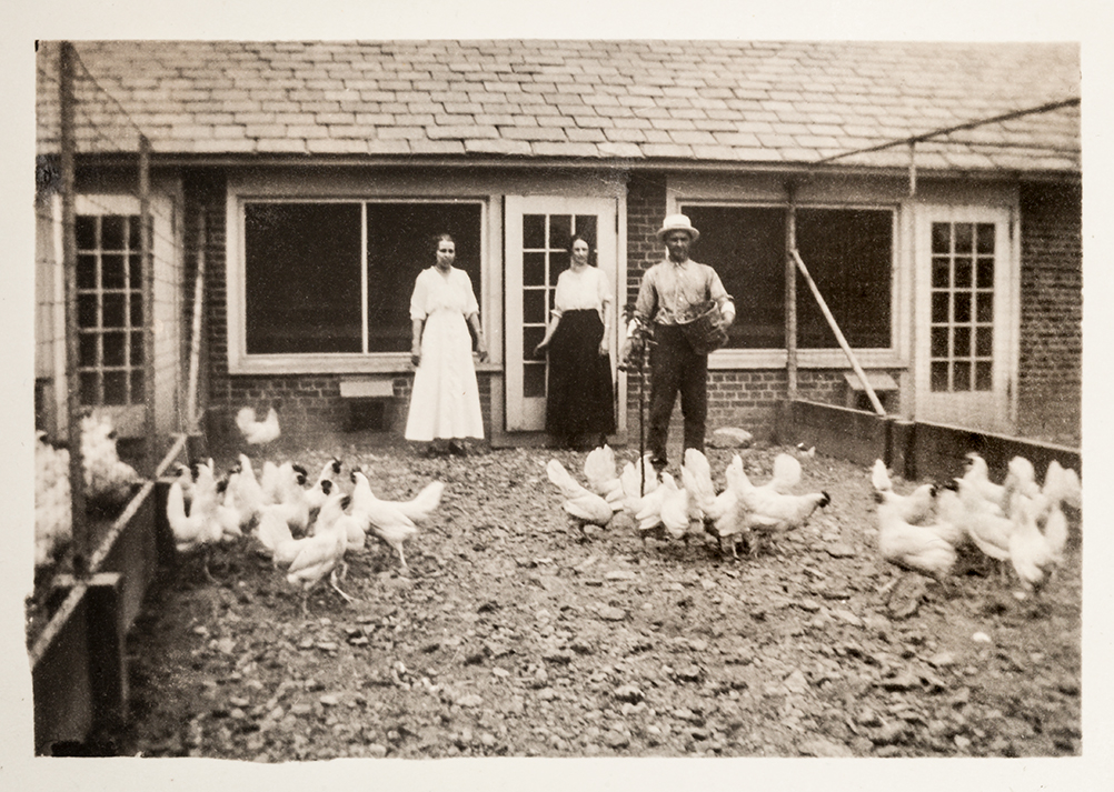 https://www.ruthmottfoundation.org/wp-content/uploads/2022/04/three-people-standing-in-a-chicken-coup-in-black-and-white.jpg