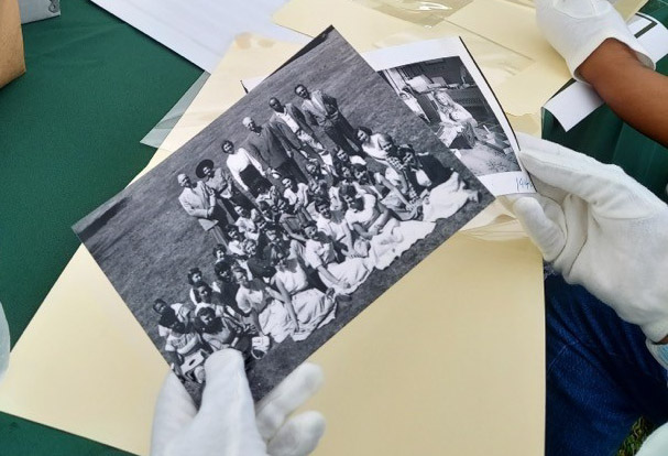 Hands in white gloves handle old black & white photos
