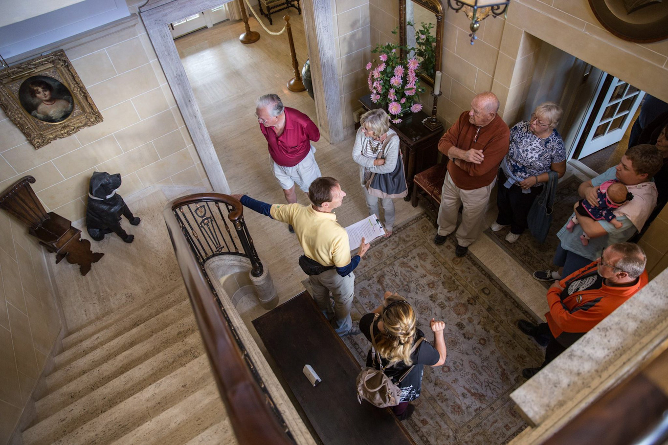 A volunteer talks to a tour group inside the foyer in the house at Applewood