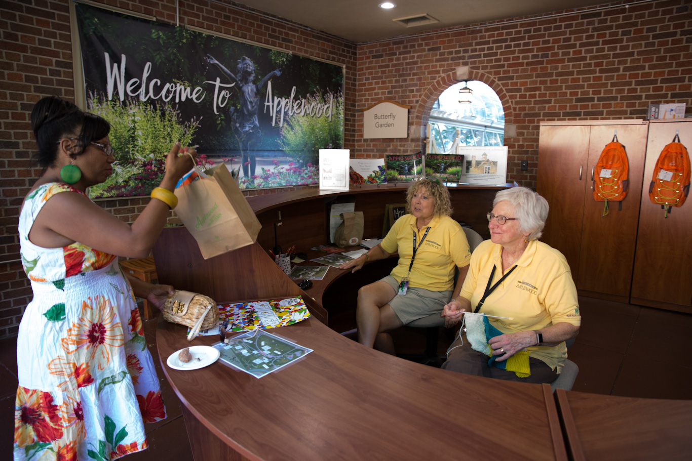 Volunteers assist a guest at the visitor services desk