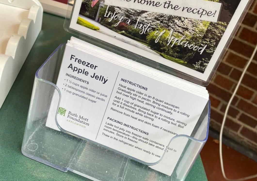 A stack of apple jelly recipe cards in a plastic container