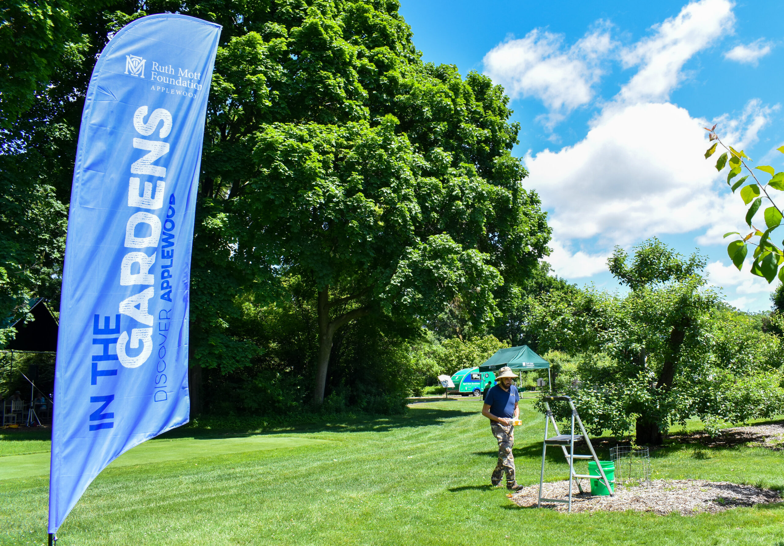 https://www.ruthmottfoundation.org/wp-content/uploads/2023/03/in-the-gardens-blue-banner-flying-outside-scaled.jpg