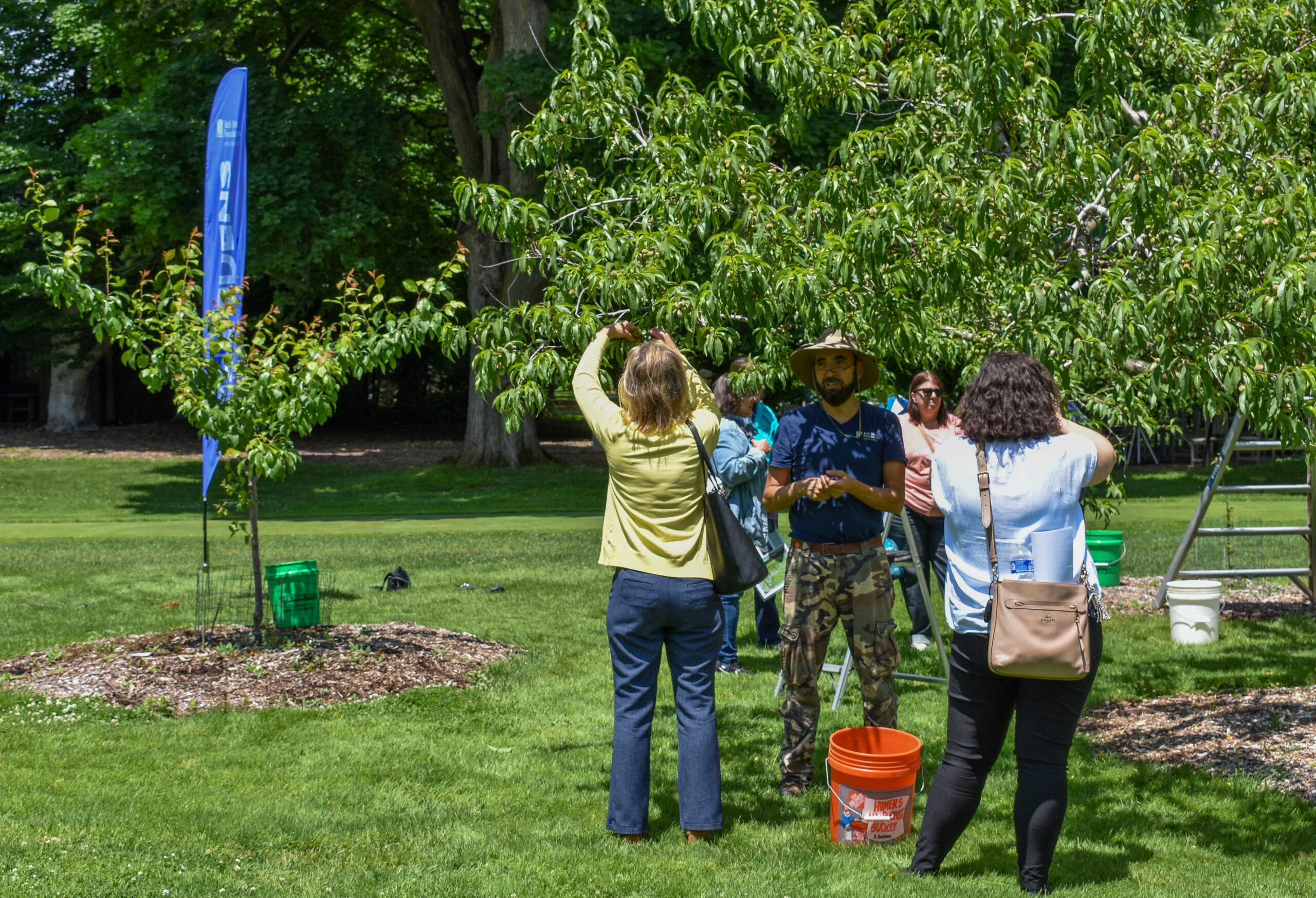 https://www.ruthmottfoundation.org/wp-content/uploads/2023/03/people-standing-around-a-tree-at-applewood-scaled.jpg