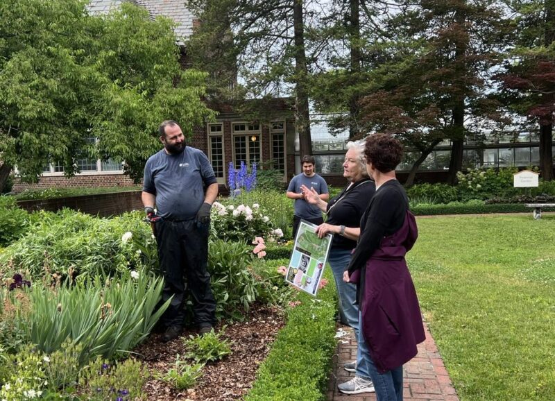 Group of people observing and discussing plants in Applewood Programs garden.